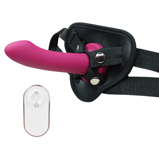 Pink silicone dildo with black harness and remote control on a white background